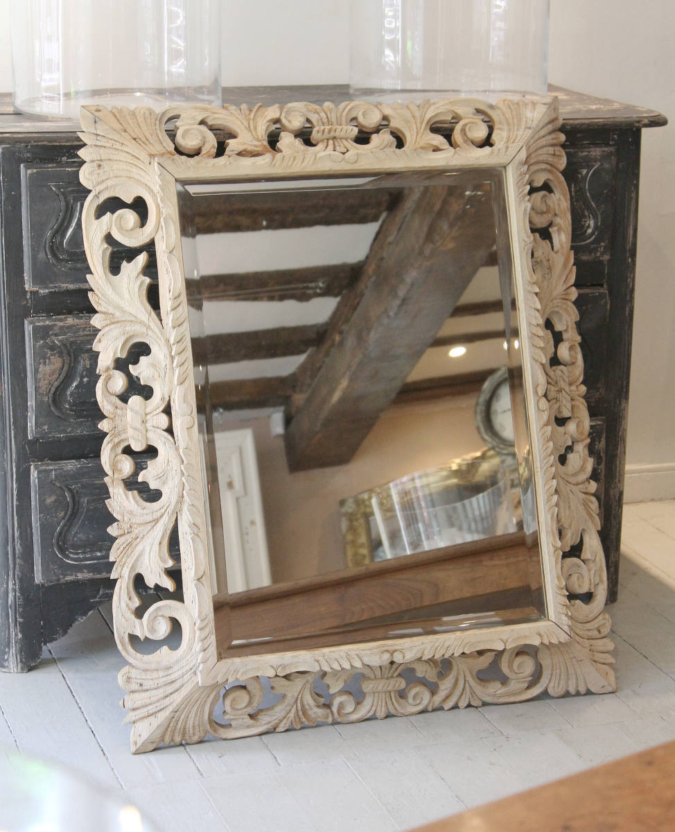 A classic French carved oak framed mirror with a bevelled glass palte