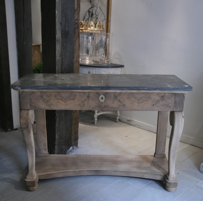 A walnut console with a marble top