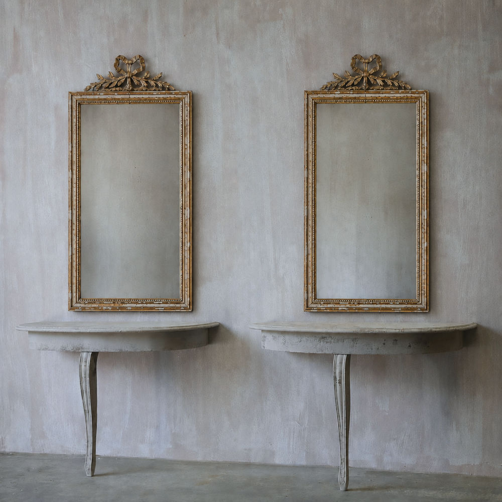 An elegant pair of demi lune consoles with distressed paint