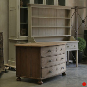 An early bow fronted chest of drawers in solid oak